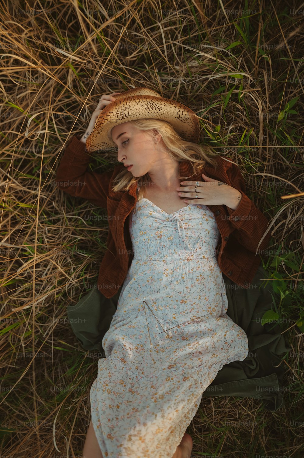 a woman laying on the ground wearing a hat