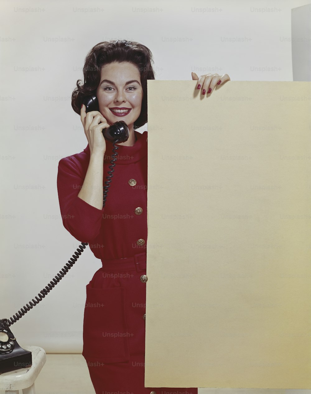 a woman in a red dress talking on a telephone