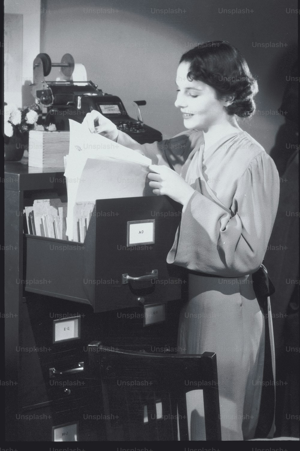 uma mulher está olhando através de um armário de arquivos