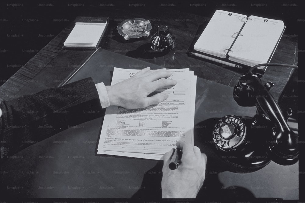 a person sitting at a desk with a pen and paper