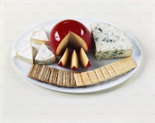 une assiette blanche garnie de fromage et de craquelins