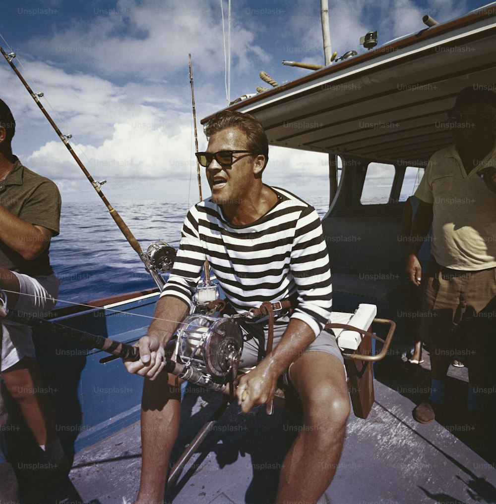 um homem sentado em um barco segurando uma vara de pesca