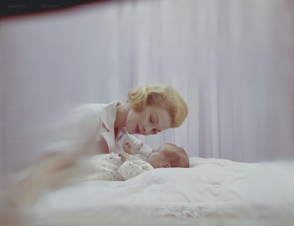 a woman laying in bed with a baby