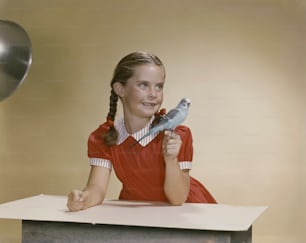 Une jeune fille tenant un oiseau sur une table