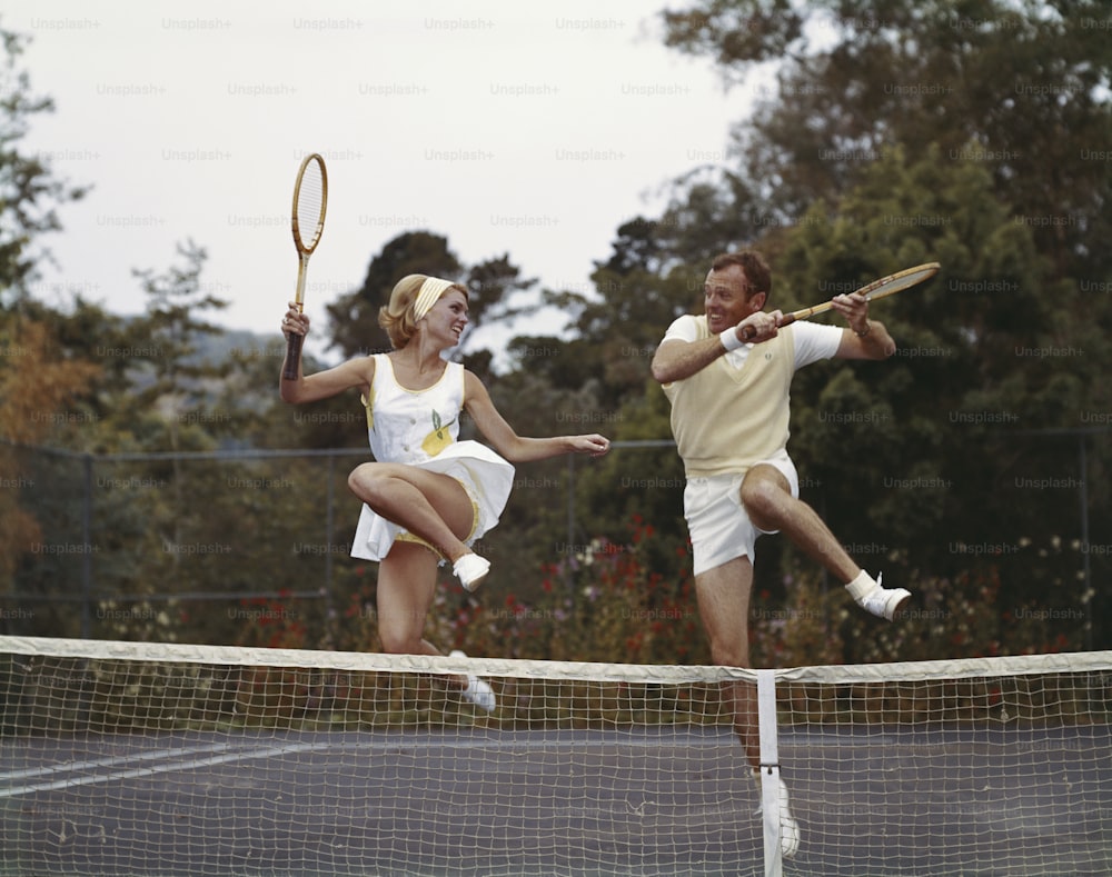 um homem e uma mulher jogando tênis em uma quadra de tênis