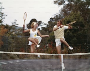 Un hombre y una mujer jugando al tenis en una cancha de tenis