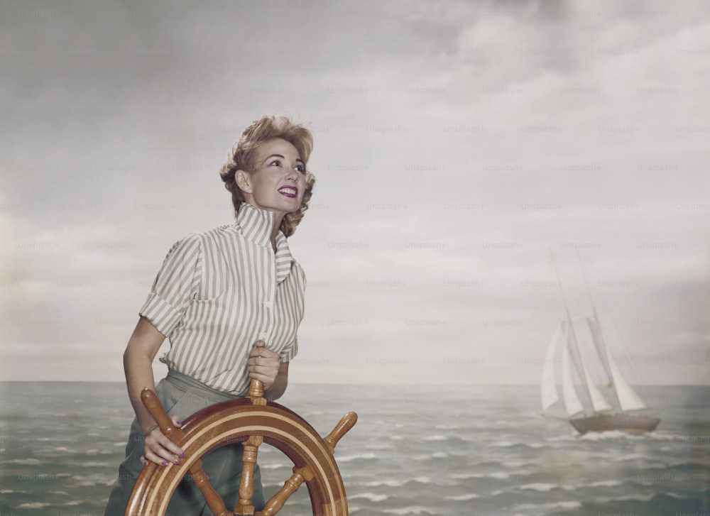 una donna in piedi sul volante di una nave