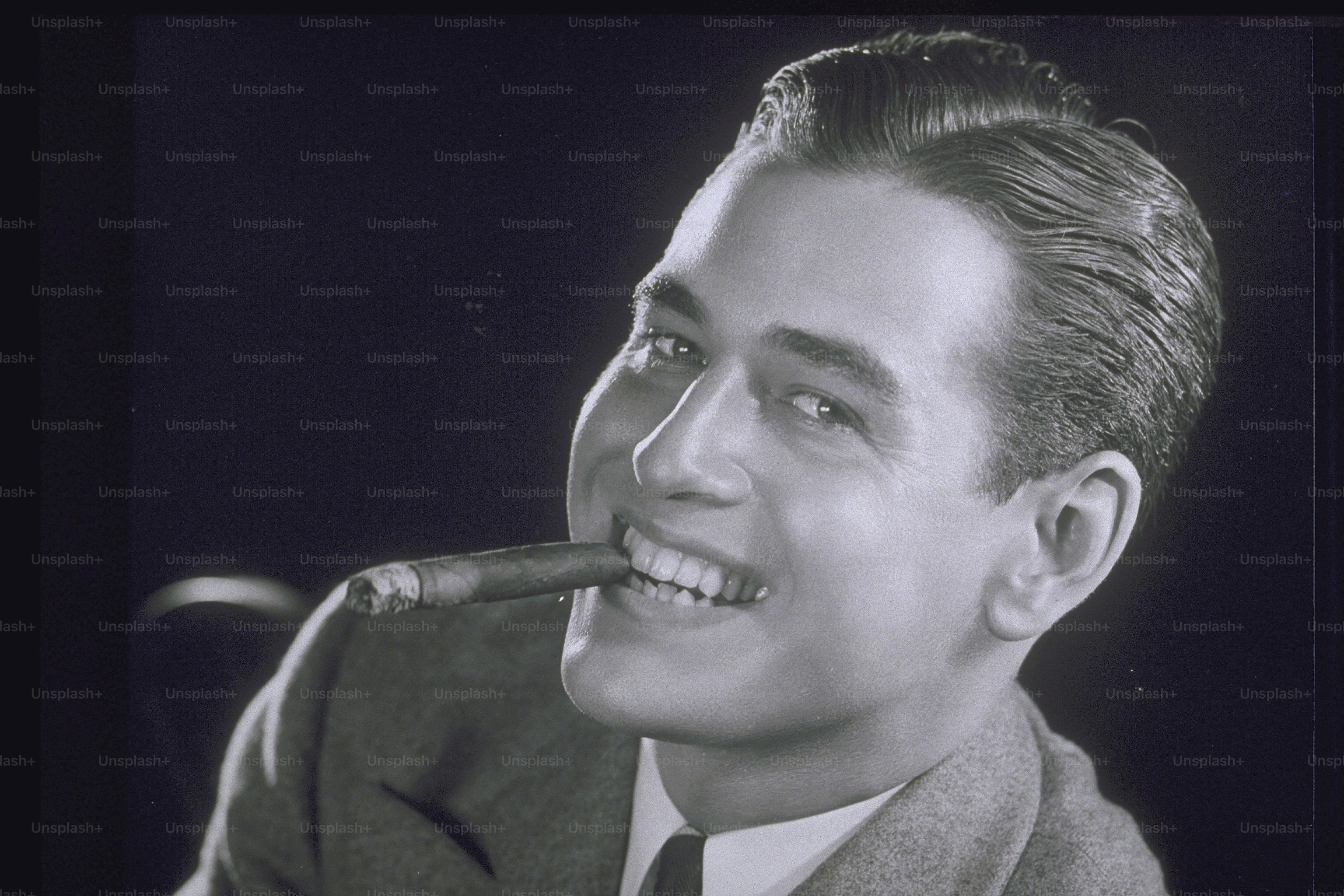 a black and white photo of a man smoking a cigarette