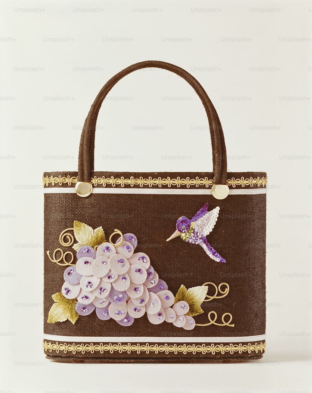 a brown purse with a bird and flowers on it