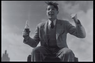a black and white photo of a man holding a beer