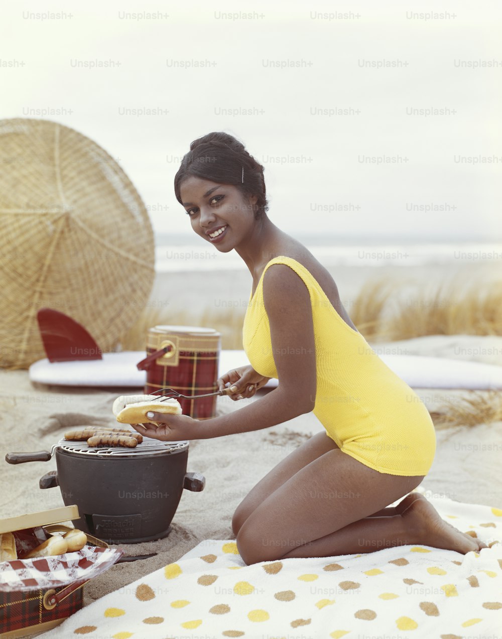 a woman in a yellow bathing suit sitting on a beach