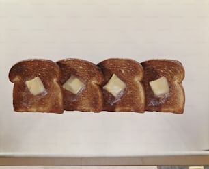 cuatro trozos de pan con mantequilla
