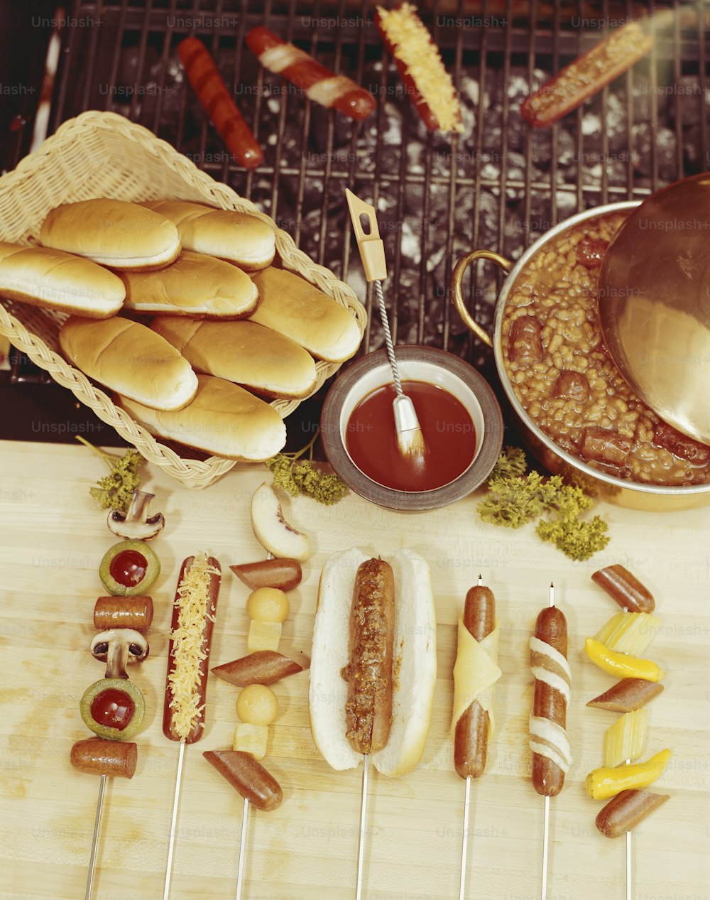 hotdogs, corn dogs, and other foods on a grill