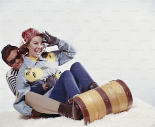a man and a woman sitting on the snow
