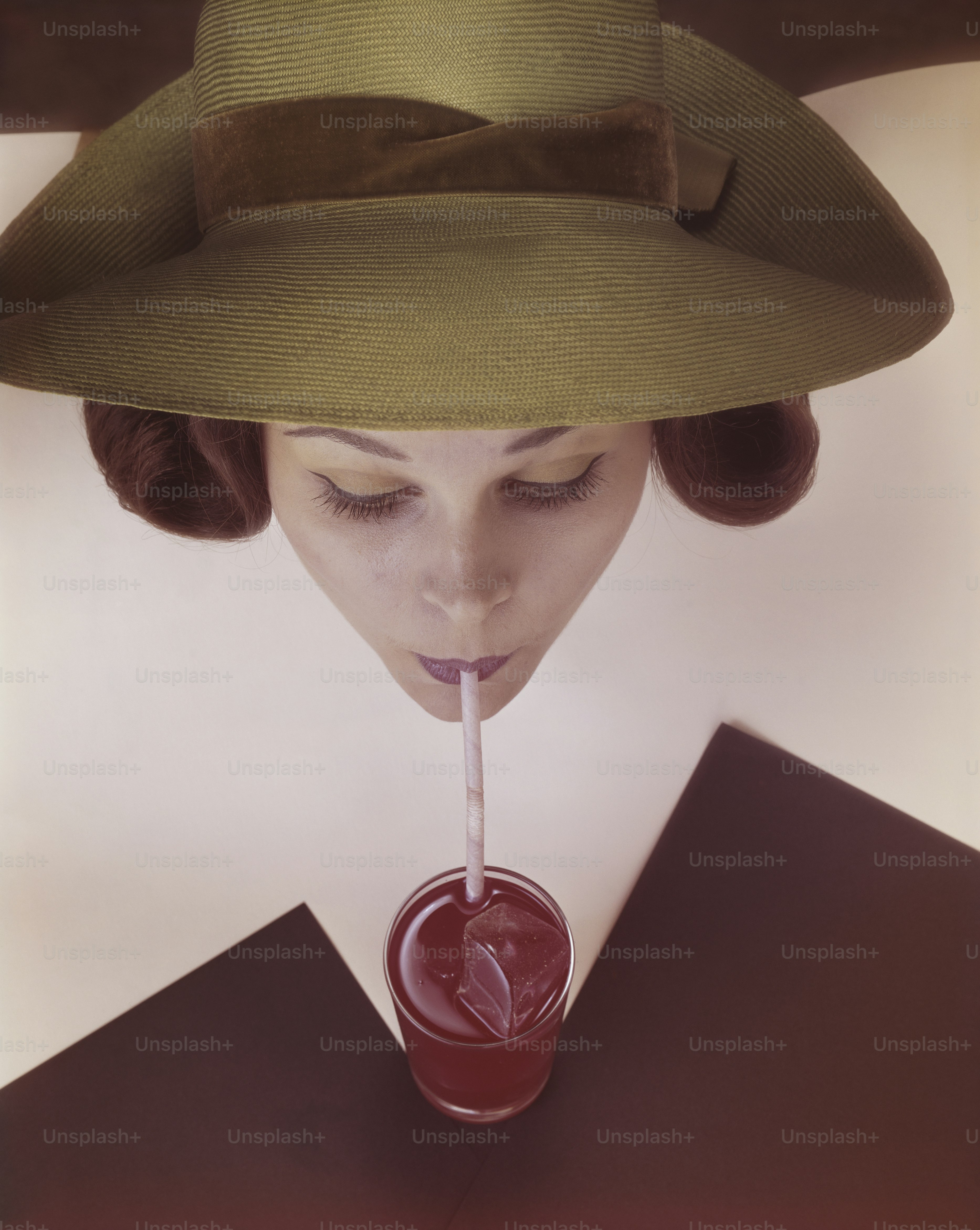 a woman with a straw hat drinking a drink