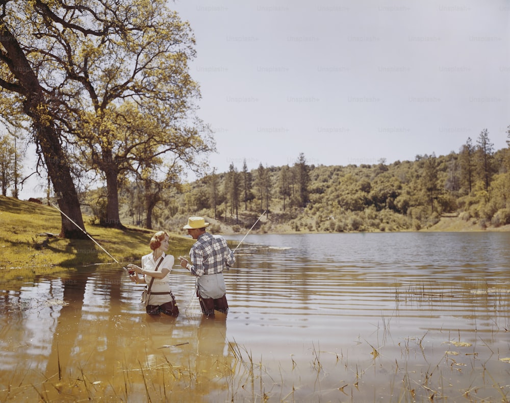 a man and a woman fishing in a lake