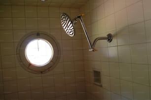 Vista di un soffione doccia d'epoca in un box doccia piastrellato, 1960 circa. (Foto di Tom Kelley/Getty Images)