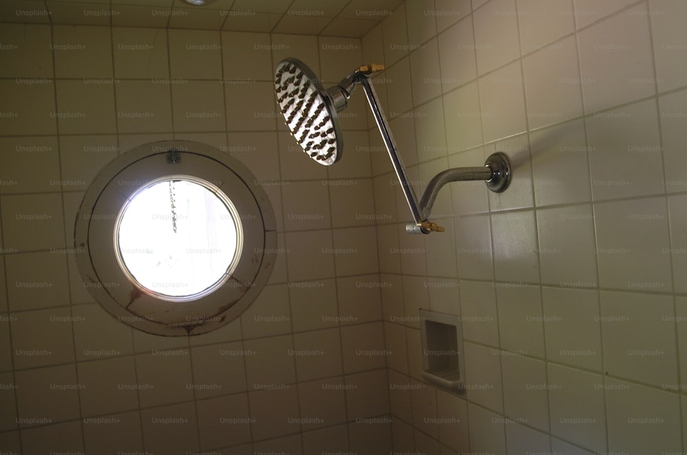 Vista de un cabezal de ducha vintage en una cabina de ducha de azulejos, hacia la década de 1960. (Foto de Tom Kelley/Getty Images)