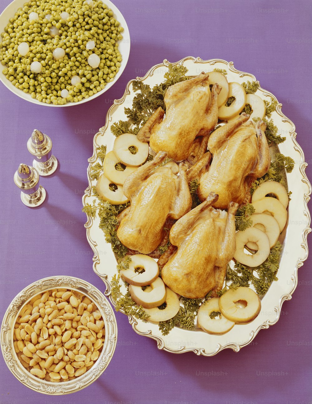 紫色のテーブルの上の鶏肉、キノコ、エンドウ豆、エンドウ豆の盛り合わせ