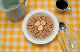 Vista de una mesa con un tazón de cereales para el desayuno (y rodajas de plátano), una taza de café y una jarra de leche, mediados y finales del siglo XX. (Foto de Tom Kelley/Getty Images)