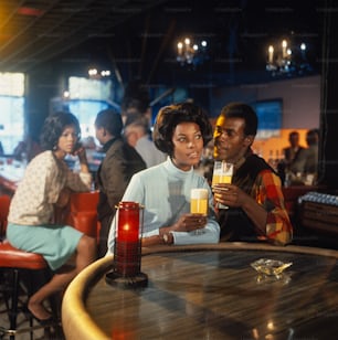 a couple of people sitting at a table with drinks
