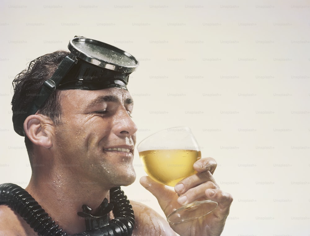 Un uomo con gli occhiali in testa che tiene un bicchiere di vino