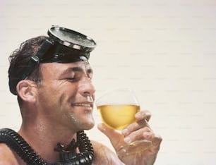a man with a goggles on his head holding a glass of wine