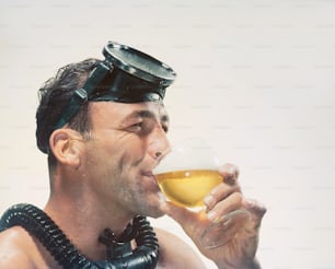 Un hombre con una máscara de gas bebiendo un vaso de cerveza