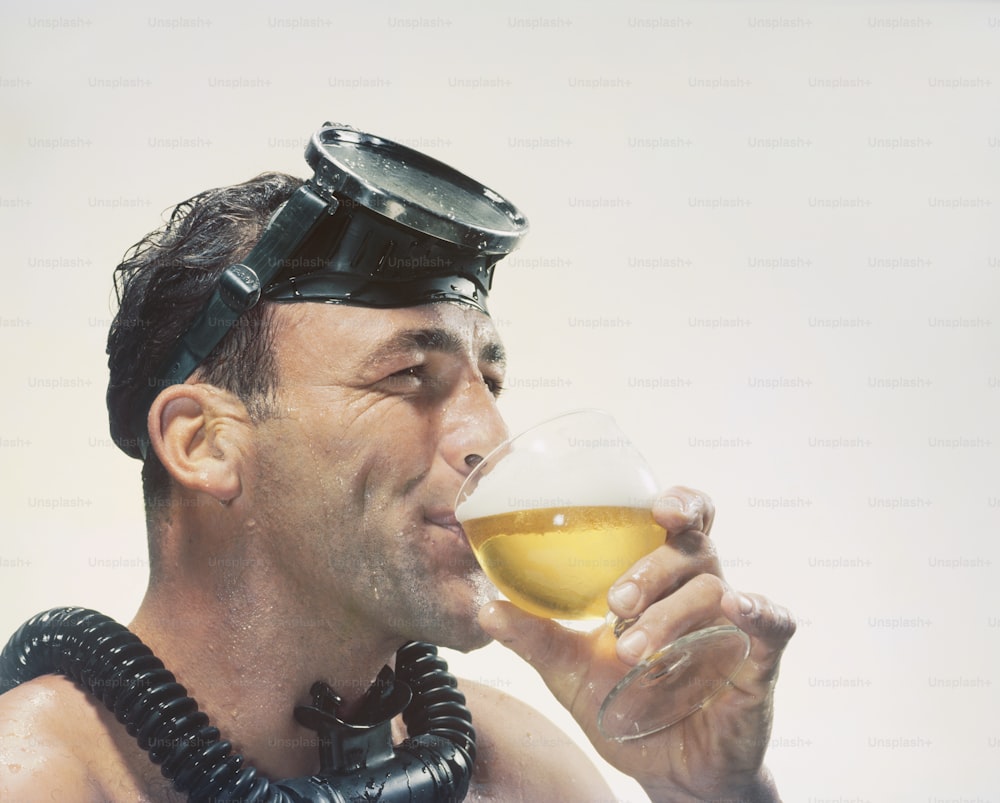 a man wearing a gas mask drinking a glass of beer