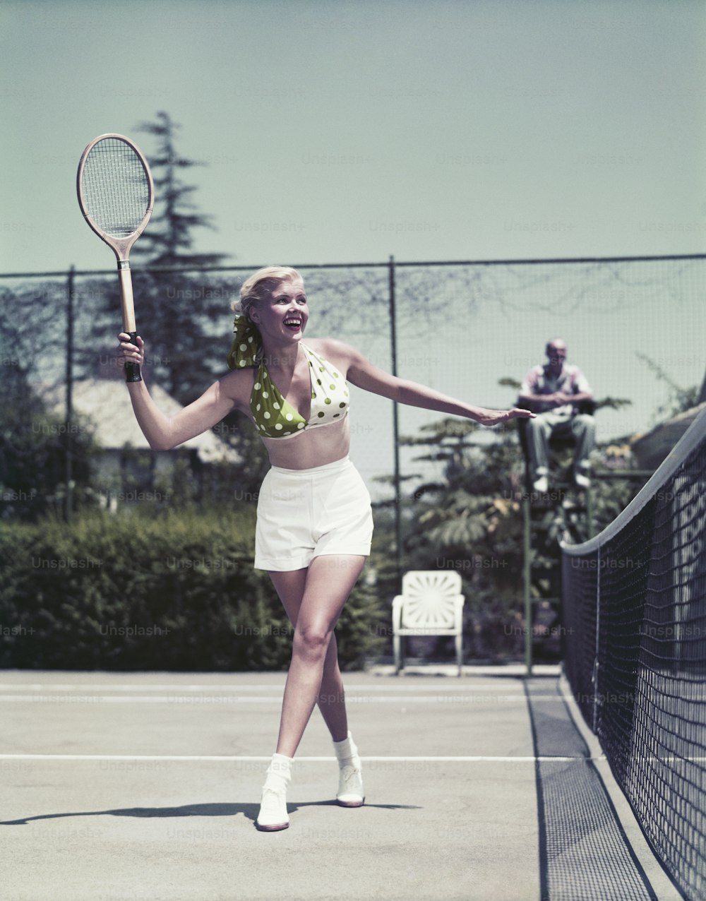 a woman holding a tennis racquet on a tennis court