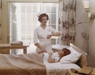 a woman in a nurse's uniform talking to a child in a hospital bed