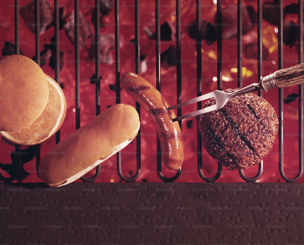 1972 : Un hamburger et un hot-dog sur le gril avec un fond de charbon de bois chaud en 1972. (Photo de Tom Kelley/Getty Images)