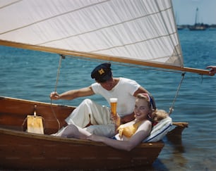 a man and a woman sitting in a boat on the water