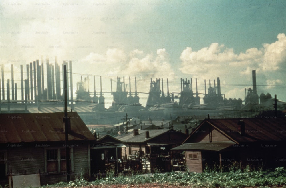 View of factory smokestacks seen over the roofs of single story homes, 1941 or 1942. (Photo by Hulton Archive/Getty Images)