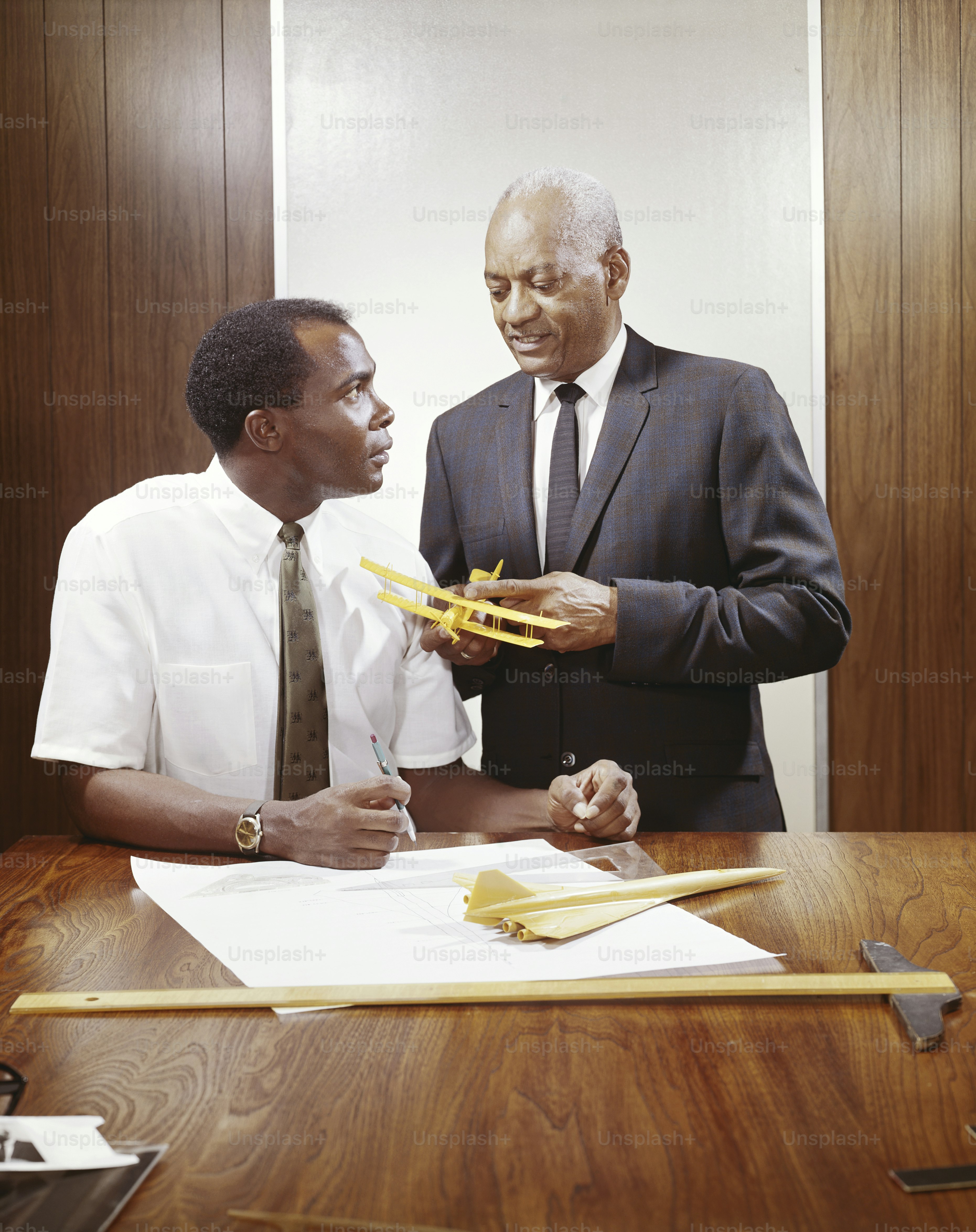 a couple of men standing next to each other at a table