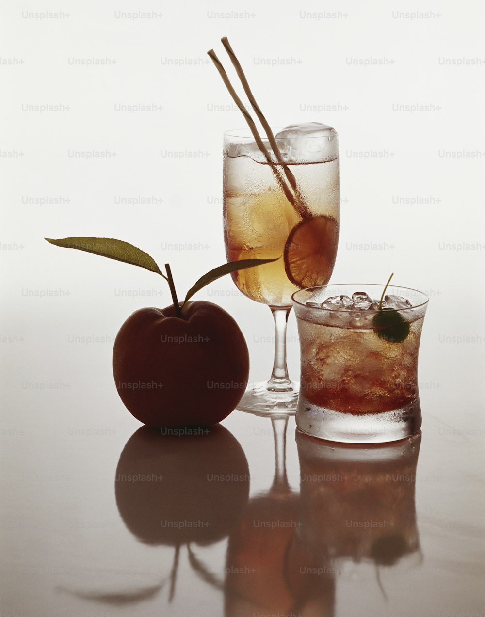 an apple and a glass of liquid on a table