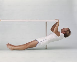 a man in white shirt doing a plank exercise