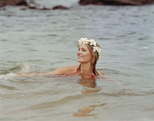 uma mulher na água usando uma coroa de flores