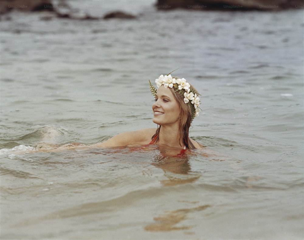 a woman in the water wearing a flower crown