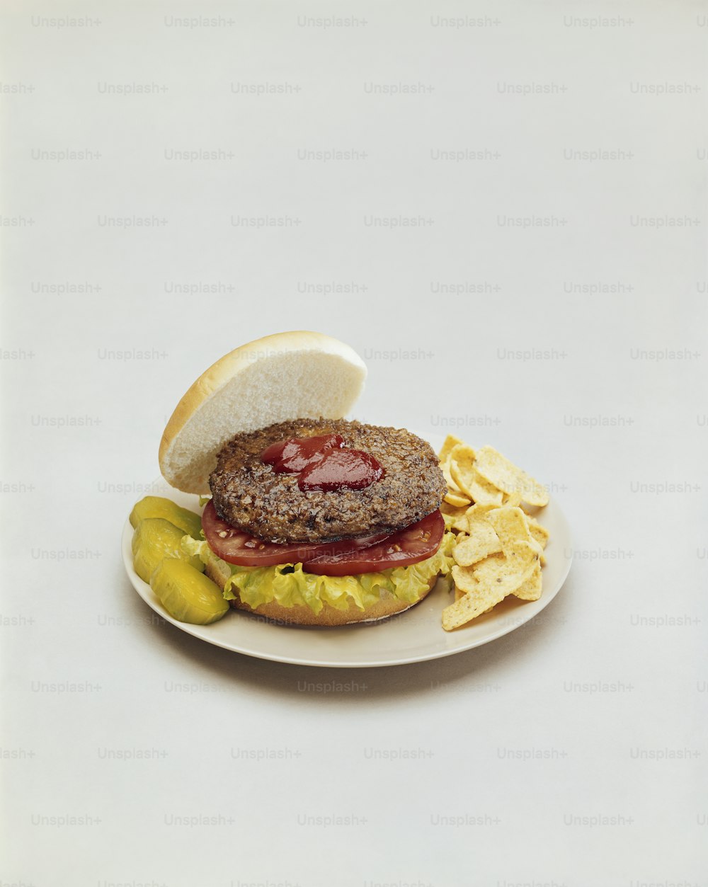un hamburger su un piatto con patatine e un sottaceto