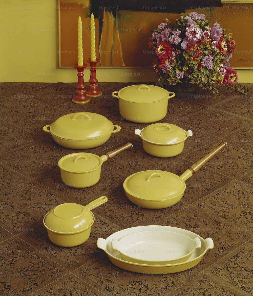 a table topped with yellow pots and pans