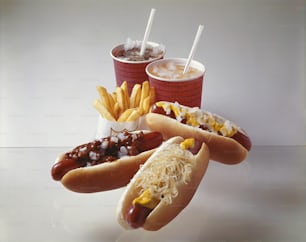 a couple of hot dogs with toppings and french fries
