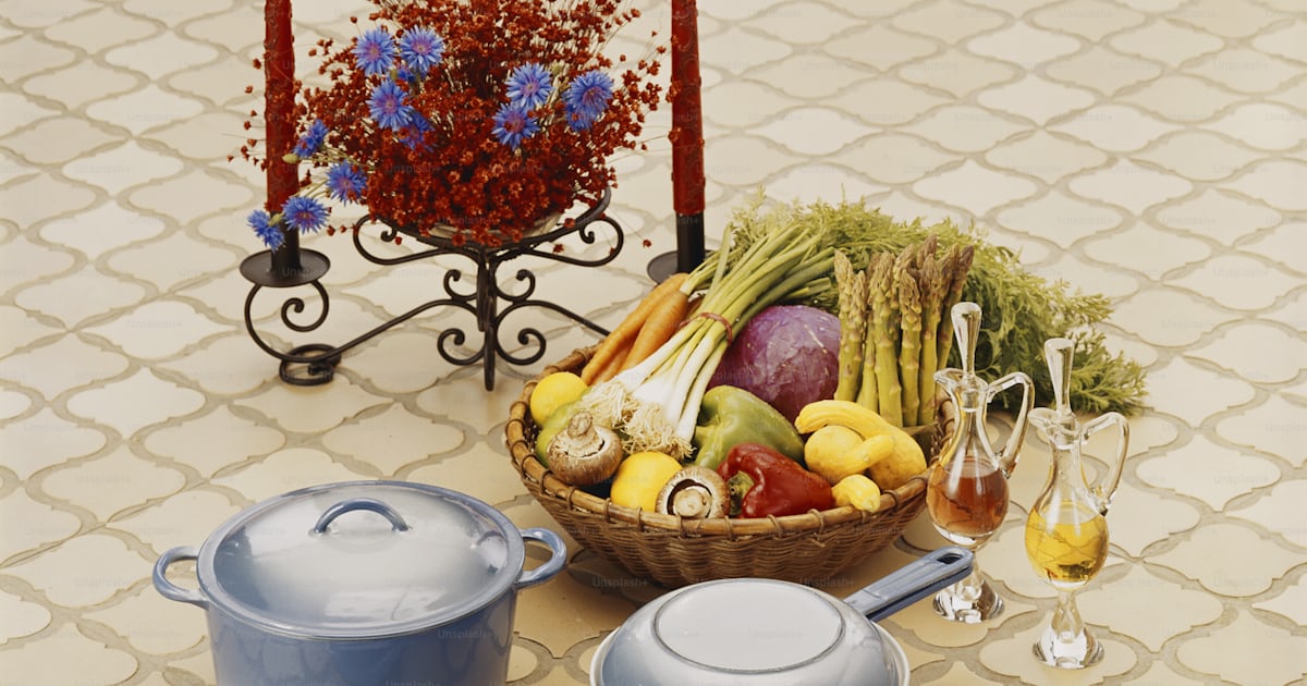 A table topped with a bowl of fruit and a basket of vegetables photo ...