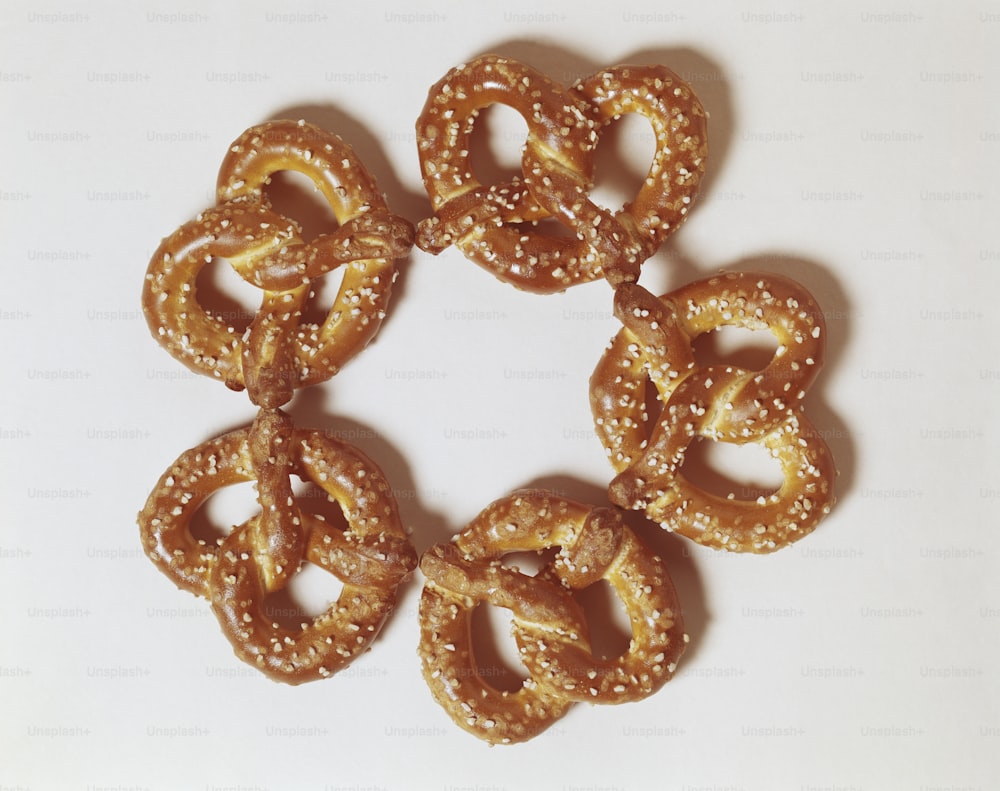 six pretzels arranged in a circle on a white surface