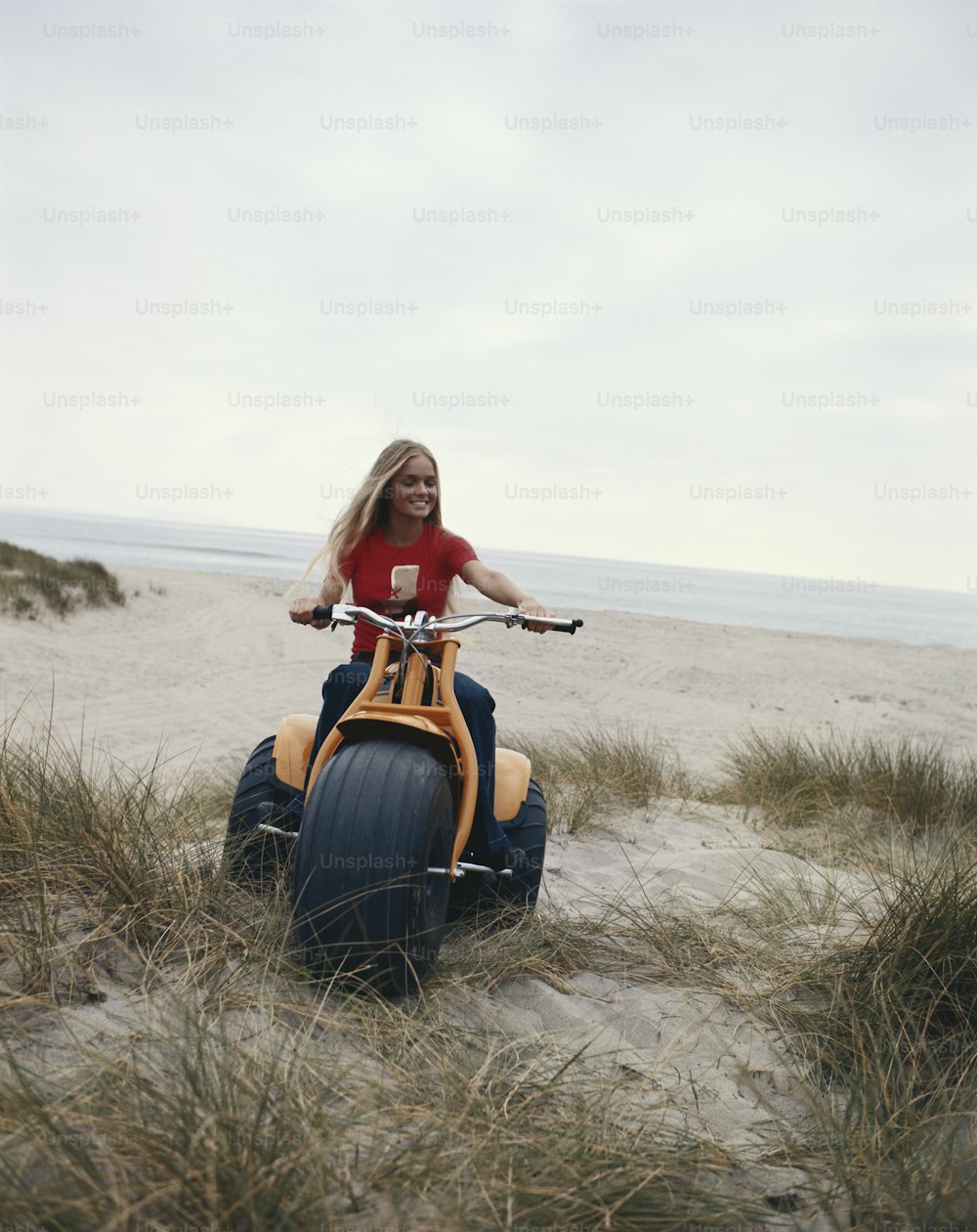 a woman is riding an inflatable vehicle on the beach