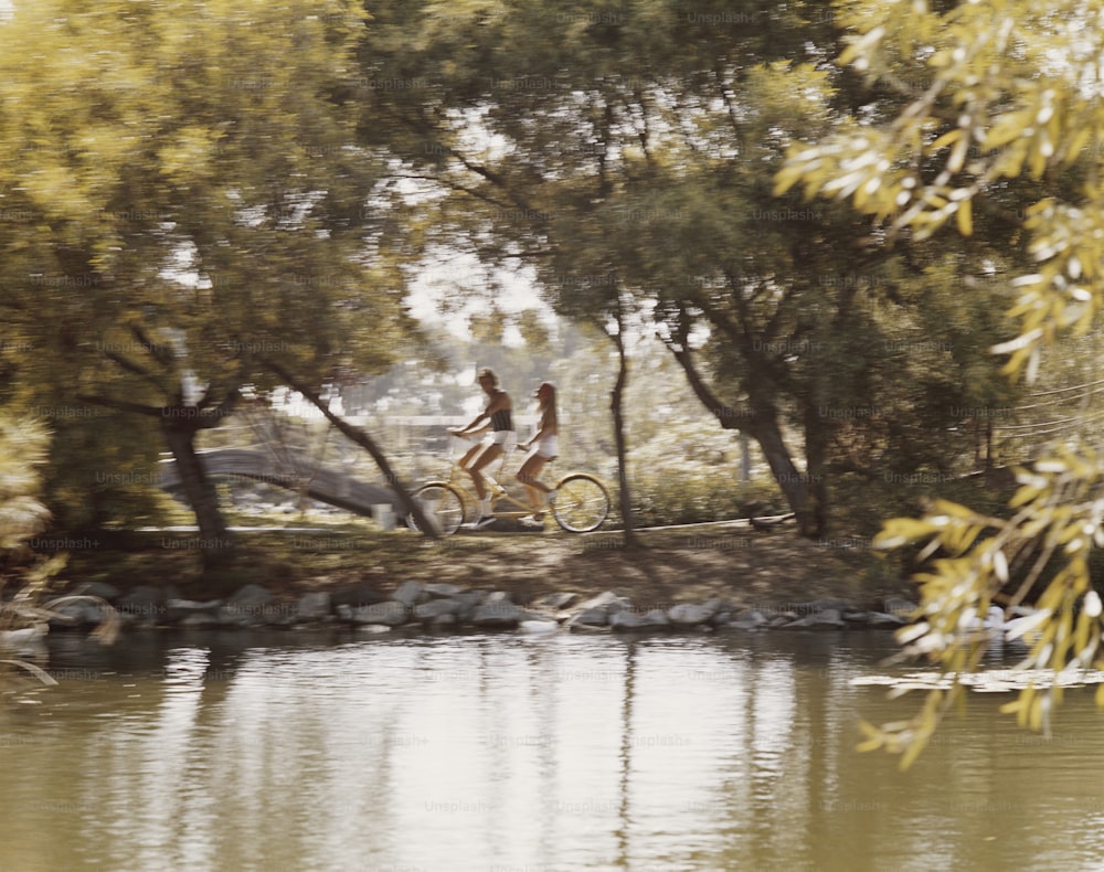 자전거를 타고 강을 따라 내려가는 두 사람