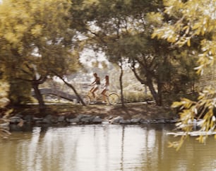a couple of people riding bikes down a river