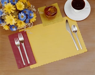 a place setting with a cup of coffee and silverware