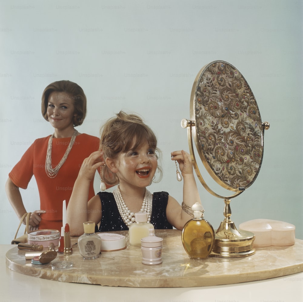 Una niña sentada frente a un espejo