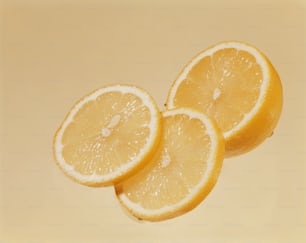 drei halbierte Zitronen auf gelbem Hintergrund